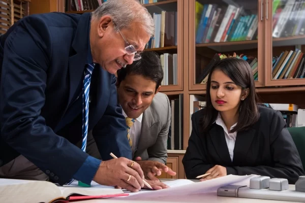 team-indian-architects-builders-drafting-discussing-housing-project-with-building-model-plan-around-conference-table-selective-focus